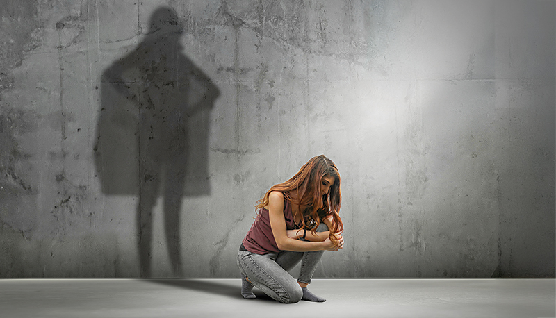 Woman crouching with shadow as super hero